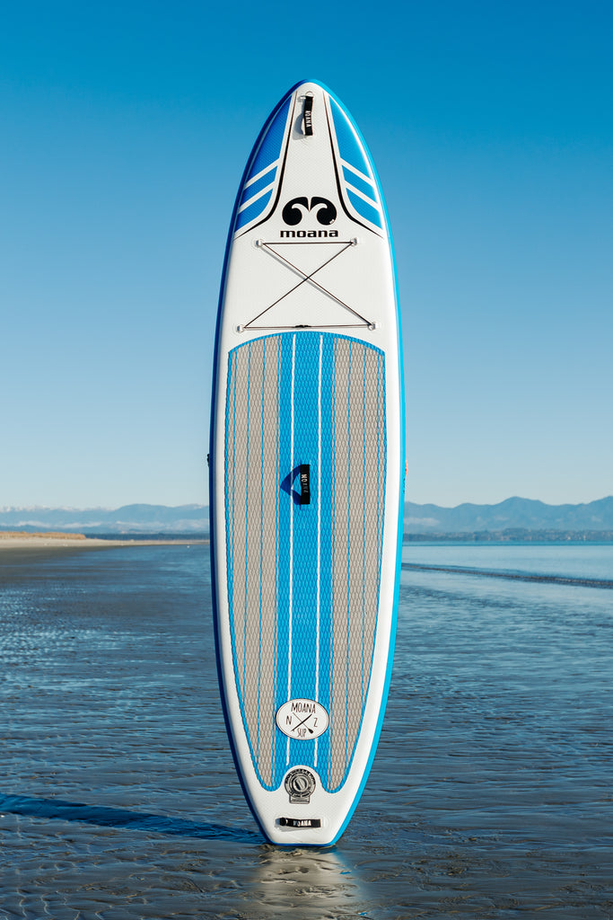 Moana Wanaga 10'6" blue inflatable stand-up paddleboard on the beach