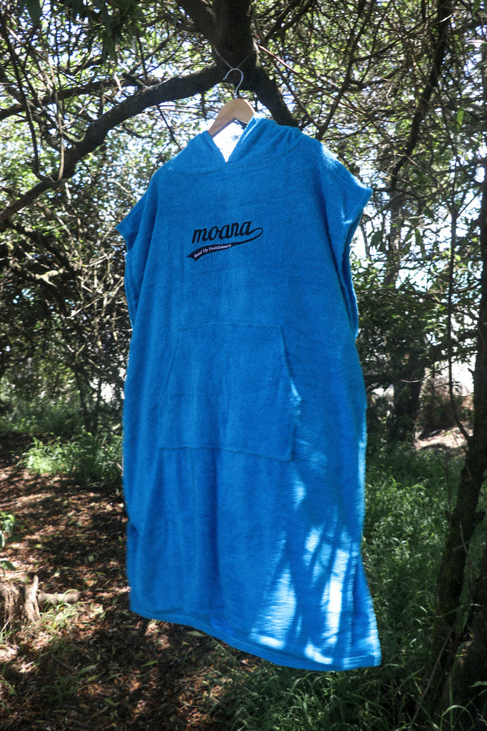 Moana hooded towel poncho blue hanging from a tree