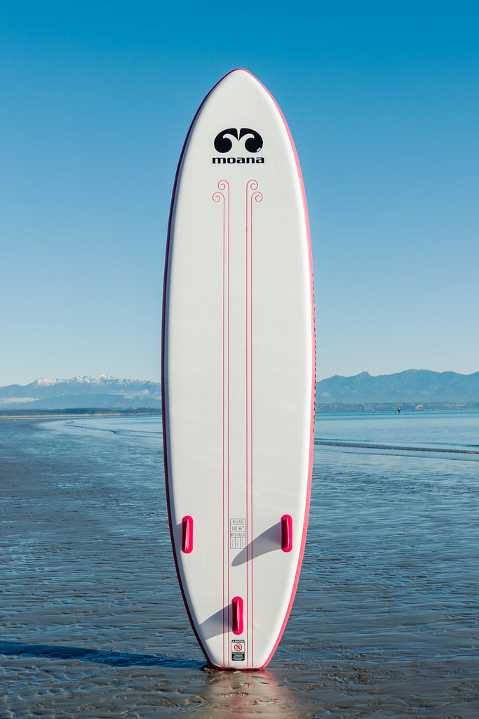 Moana Wanaga 10'6" pink inflatable stand-up paddleboard on the beach