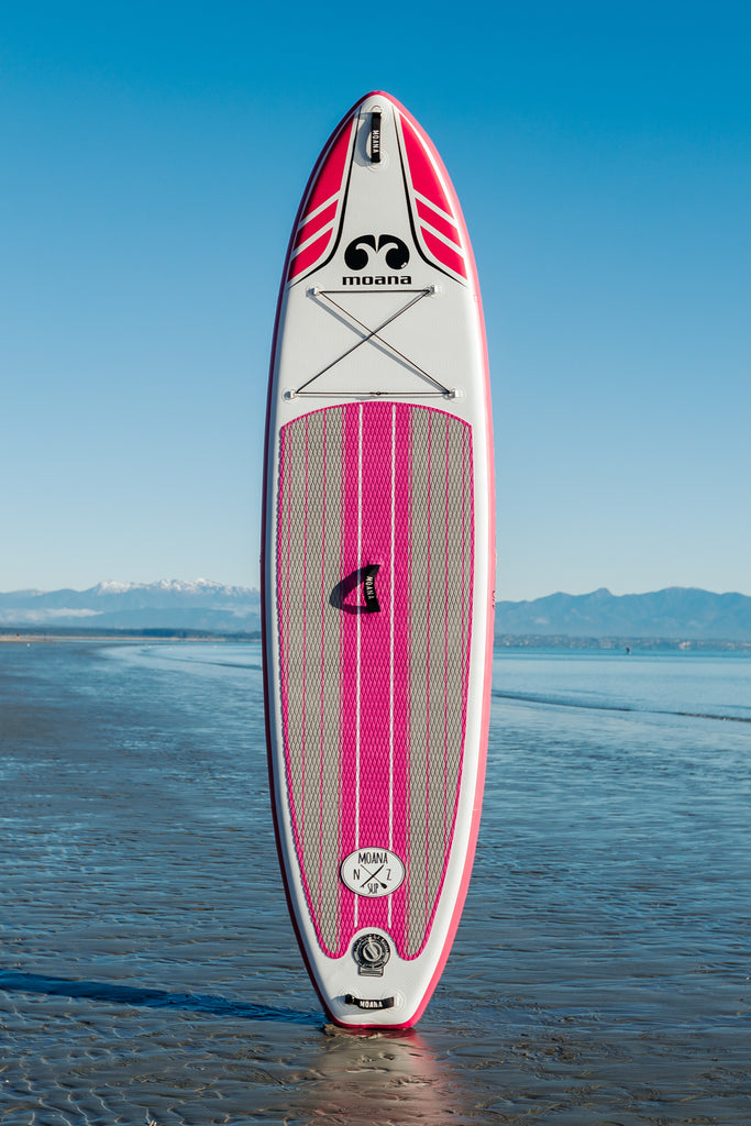 Moana Wanaga 10'6" pink inflatable stand-up paddleboard on the beach
