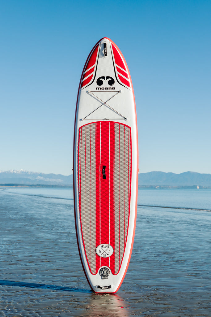 Moana Wanaga 10'6" red inflatable stand-up paddleboard on the beach